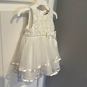 Beautiful white dress with pearls on top with bow and a pearl reem. New.